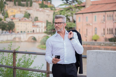 Businessman using mobile phone while standing outdoors