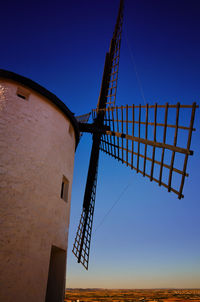 Low angle view of traditional windmill against clear blue sky