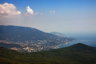 Scenic view of landscape and mountains against sky with yalta city underneath