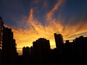 Silhouette buildings against sky during sunset