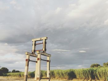 Low angle view of traditional windmill on field against sky