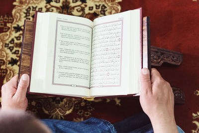 Midsection of man reading koran in mosque
