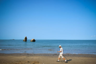 People on beach against clear sky