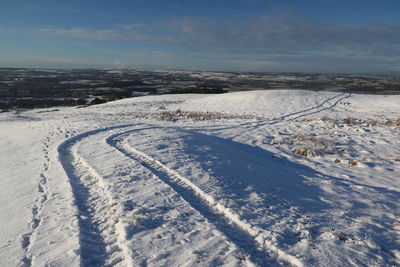 Snow covered land against sky