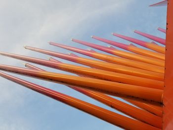 Low angle view of multi colored pencils against sky