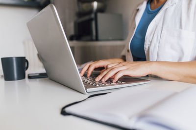 Hands of businesswoman typing on laptop