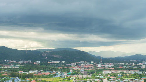 Aerial view of townscape by mountains against sky