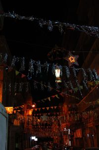 Low angle view of illuminated christmas lights at night