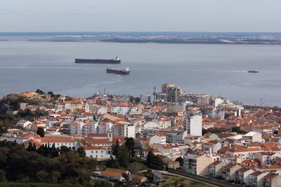 High angle view of cityscape by sea against sky