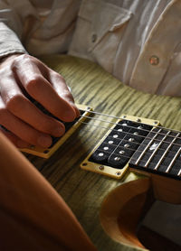 Cropped hand playing electric guitar