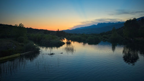 Scenic view of lake against sky at sunset