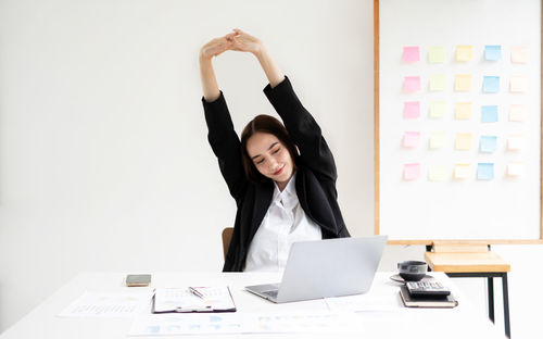 Portrait of woman using laptop at office