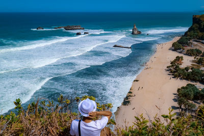 Rear view of young man looking at sea