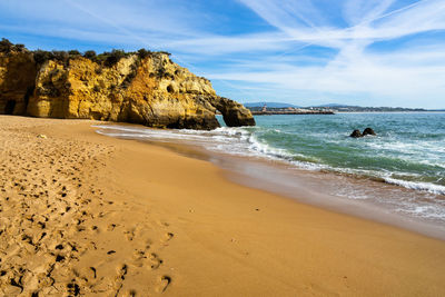 Scenic view of batata beach with with typical golden cliffs e footprints on the sand,  algarve