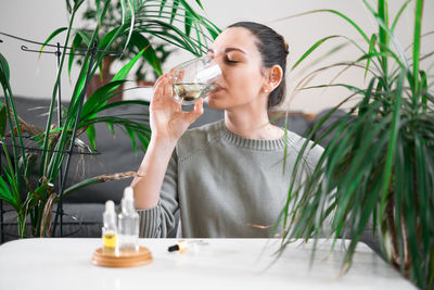 Young woman drinking healthy drink at home