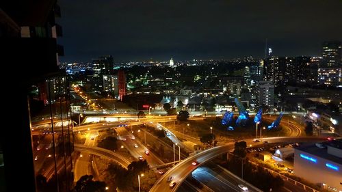 High angle view of illuminated city street and buildings at night