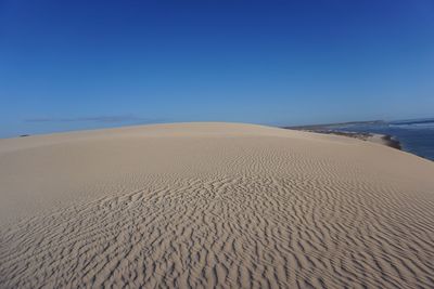 Scenic view of beach against clear blue sky