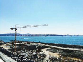 Cranes at construction site against clear sky