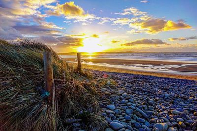 Scenic view of beach against sky during sunset