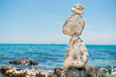 Zen stones balance at stony beach and sea background