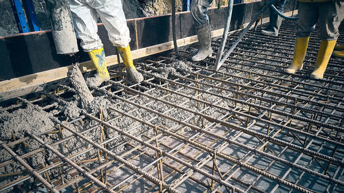 Cement works construction site. construction workers dressed in uniform pour a concrete to formwork