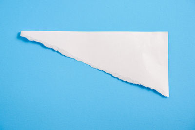 High angle view of white paper against blue background