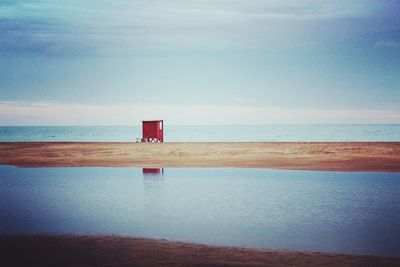 Lifeguard hut on beach against sky