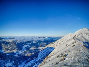 Scenic view of snowcapped mountains against clear blue sky