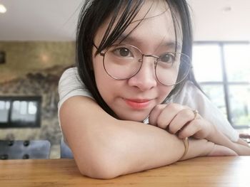 Close-up of woman looking away on table at home