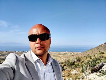Portrait of man wearing sunglasses against sky
