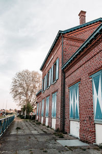 Street amidst houses and building against sky