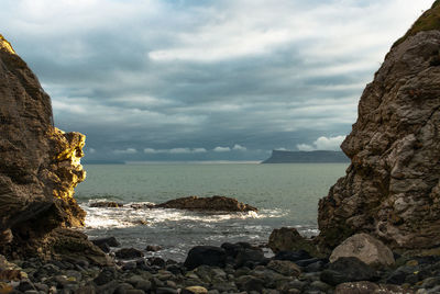 View of calm beach against clouds