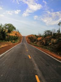 Road amidst trees against sky