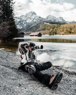 Man in hat by lake against mountains