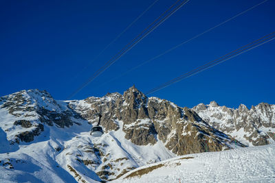 Scenic view of snowcapped mountains against clear blue sky