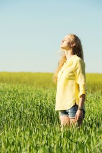 Woman wearing hat on field against clear sky