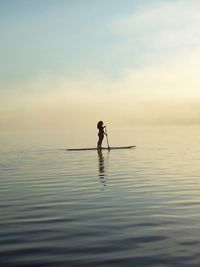 Silhouette man in sea against sky