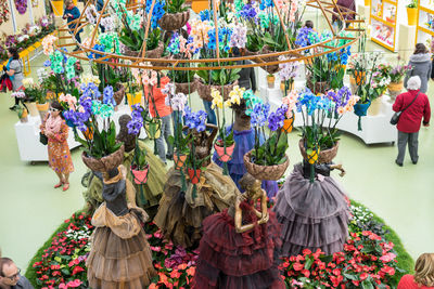 Group of people on street amidst flowering plants