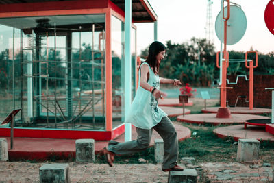 Side view of woman leaping on concretes at playground