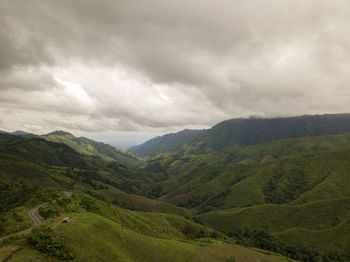 Aerial view of countryside road passing through the lush greenery tropical rain forest mountain