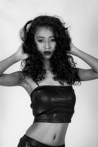 Portrait of woman standing against white background