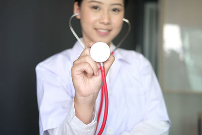 Portrait of smiling female doctor holding stethoscope in hospital