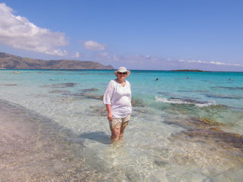 Portrait of mature woman standing in sea at beach
