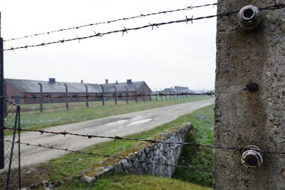 Close-up of barbed wires against sky