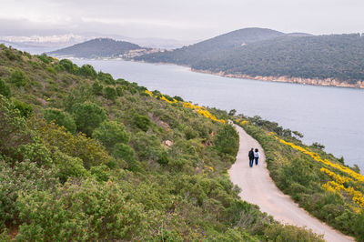 High angle view of people walking on footpath by river