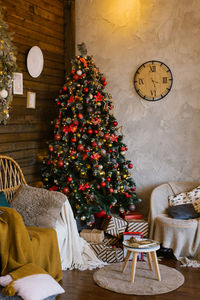 Interior of a country house room with a christmas tree with gifts, chairs with blankets