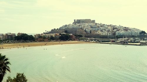 View of buildings by beach against sky
