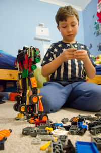 Close-up of boy playing with toy car
