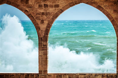 Arch bridge over sea against sky