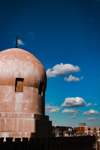 Buildings against blue sky dome of mosque